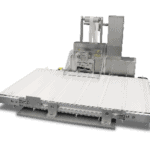 Cut to length with unwind, stacker and index conveyor cuts fibrous strap material