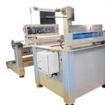 Cut to length station unwinds film from a roll, slits and trims the material, and removes and rewinds release liners